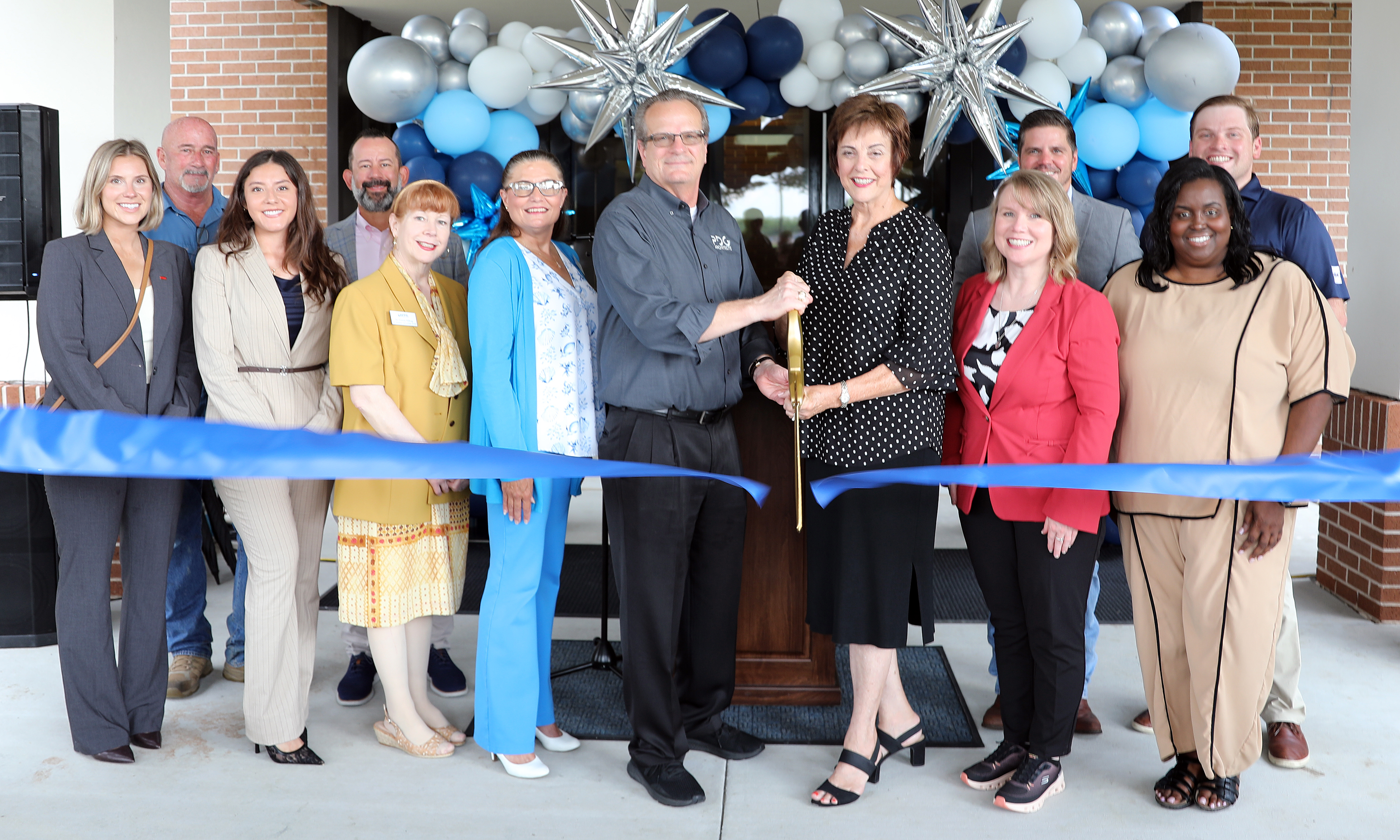 Group of people cutting a ribbon